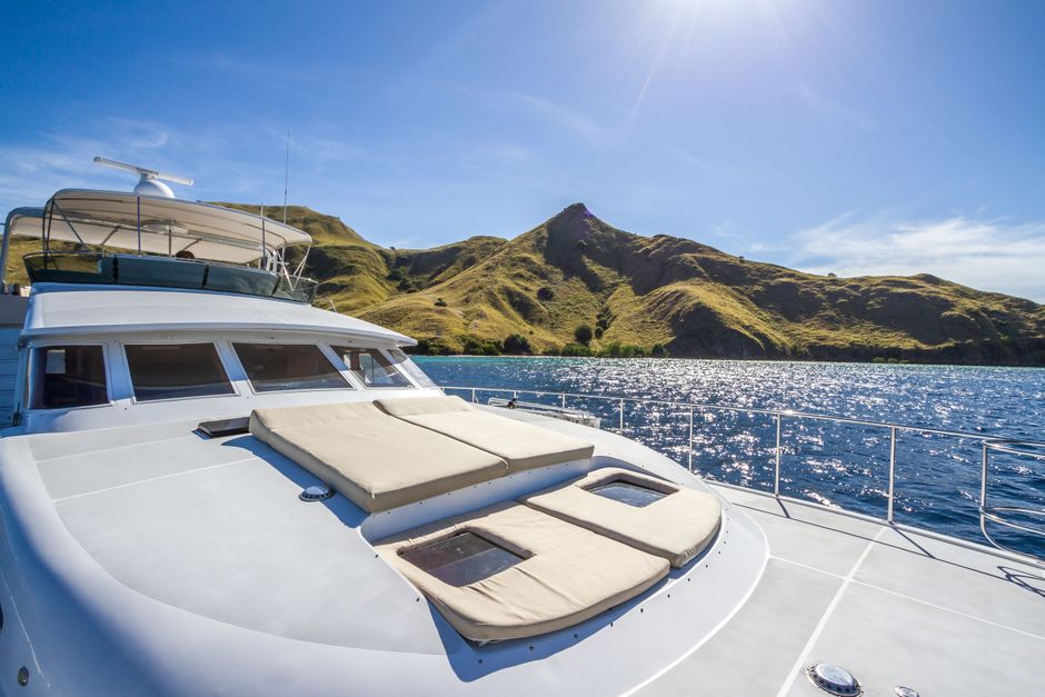 Sonnendeck einer Yacht vor grünen Inselhügeln.jpg