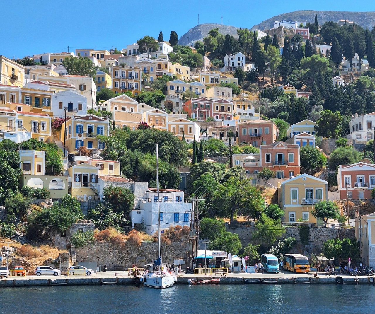 Entdecken Sie Symi, ein malerisches Segelziel im griechischen Dodekanes, wo farbenfrohe neoklassizistische Häfen, kristallklare Buchten, friedliche Ankerplätze und authentischer Inselcharme einen unvergesslichen Yachtcharter-Urlaub schaffen.